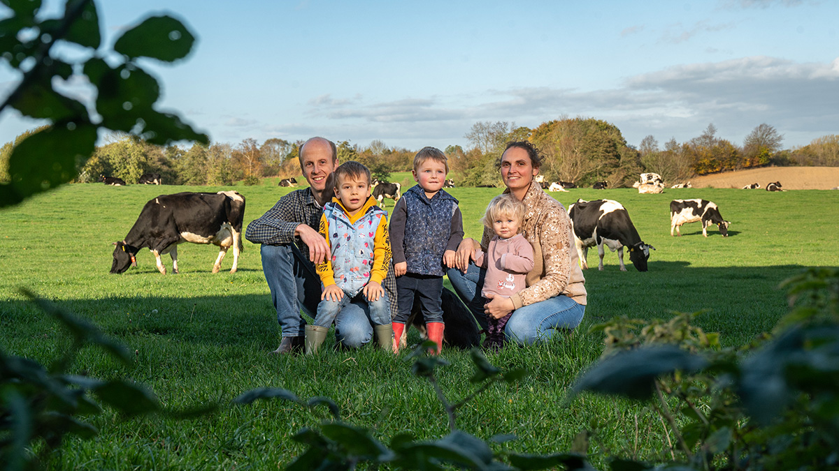 Familie auf Wiese vor Kühen