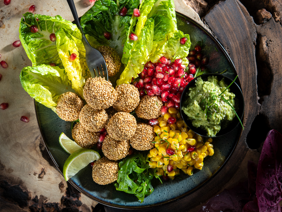 Falafel-Bowl mit Rucola, Granatapfel und Avocadocreme