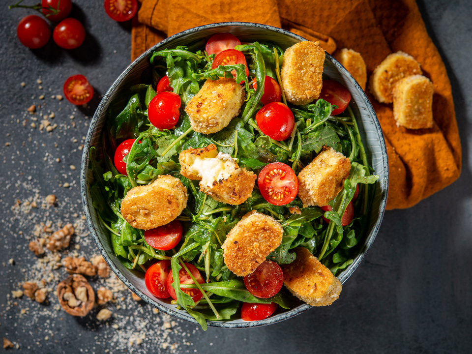 Käsetaler in Walnusskruste auf Rucola