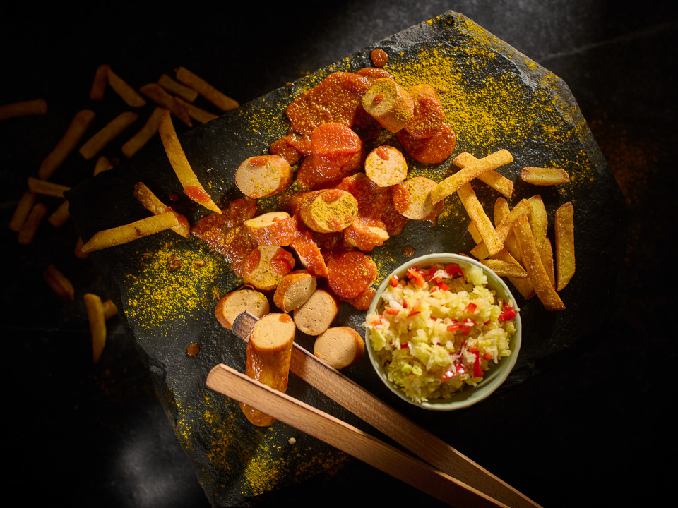 Strohschwein-Currywurst mit scharfer Soße und Krautsalat
